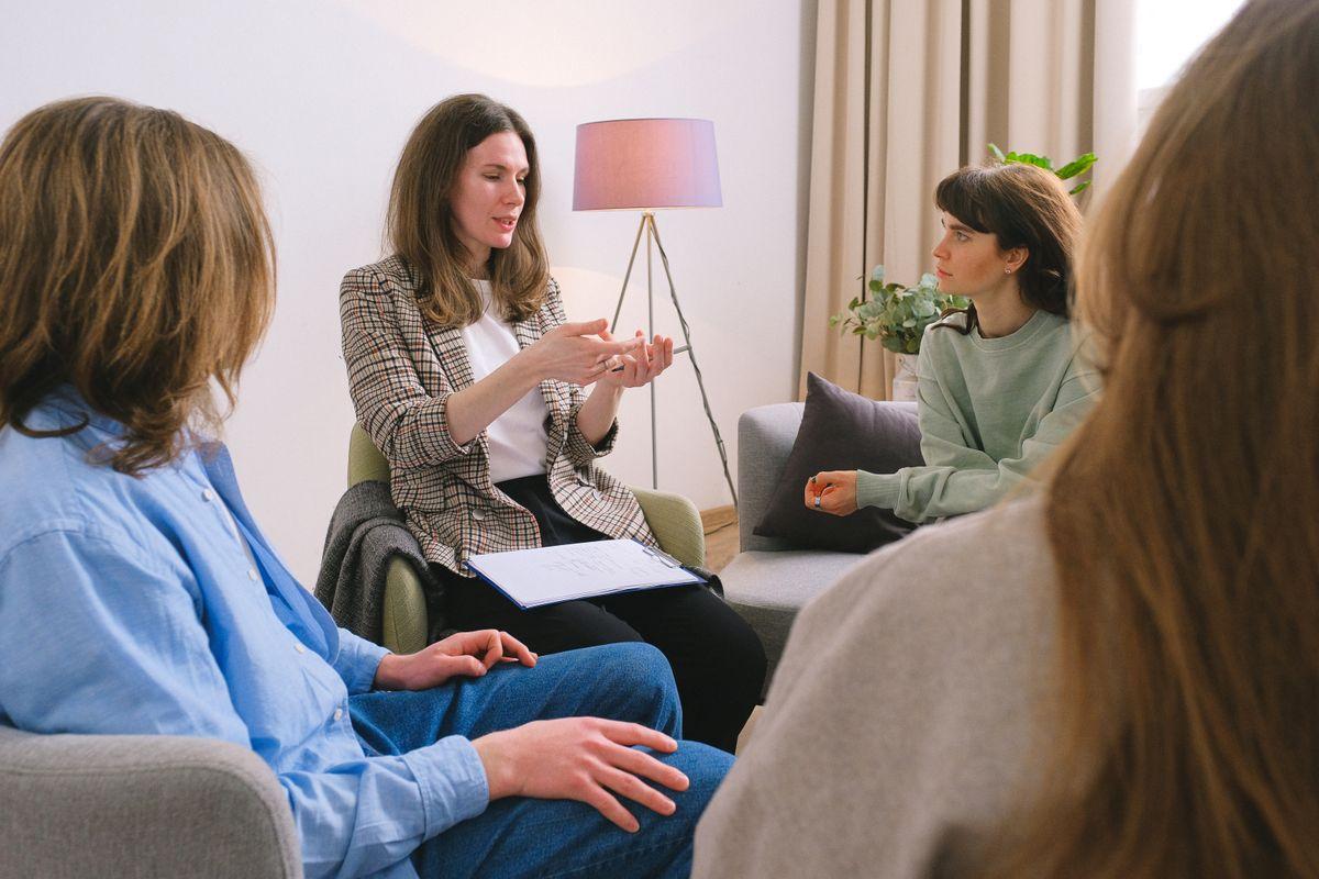 Psicóloga guiando una conversación en un grupo de mujeres sentadas en círculo