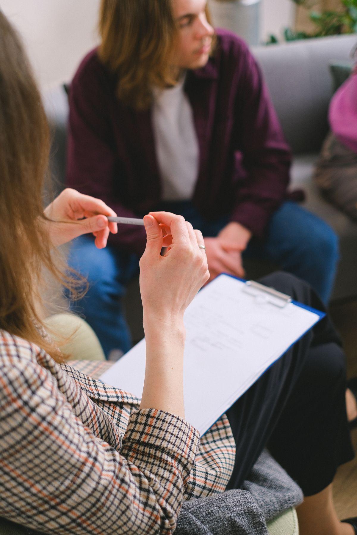 Psicóloga tomando notas durante una sesión de evaluación