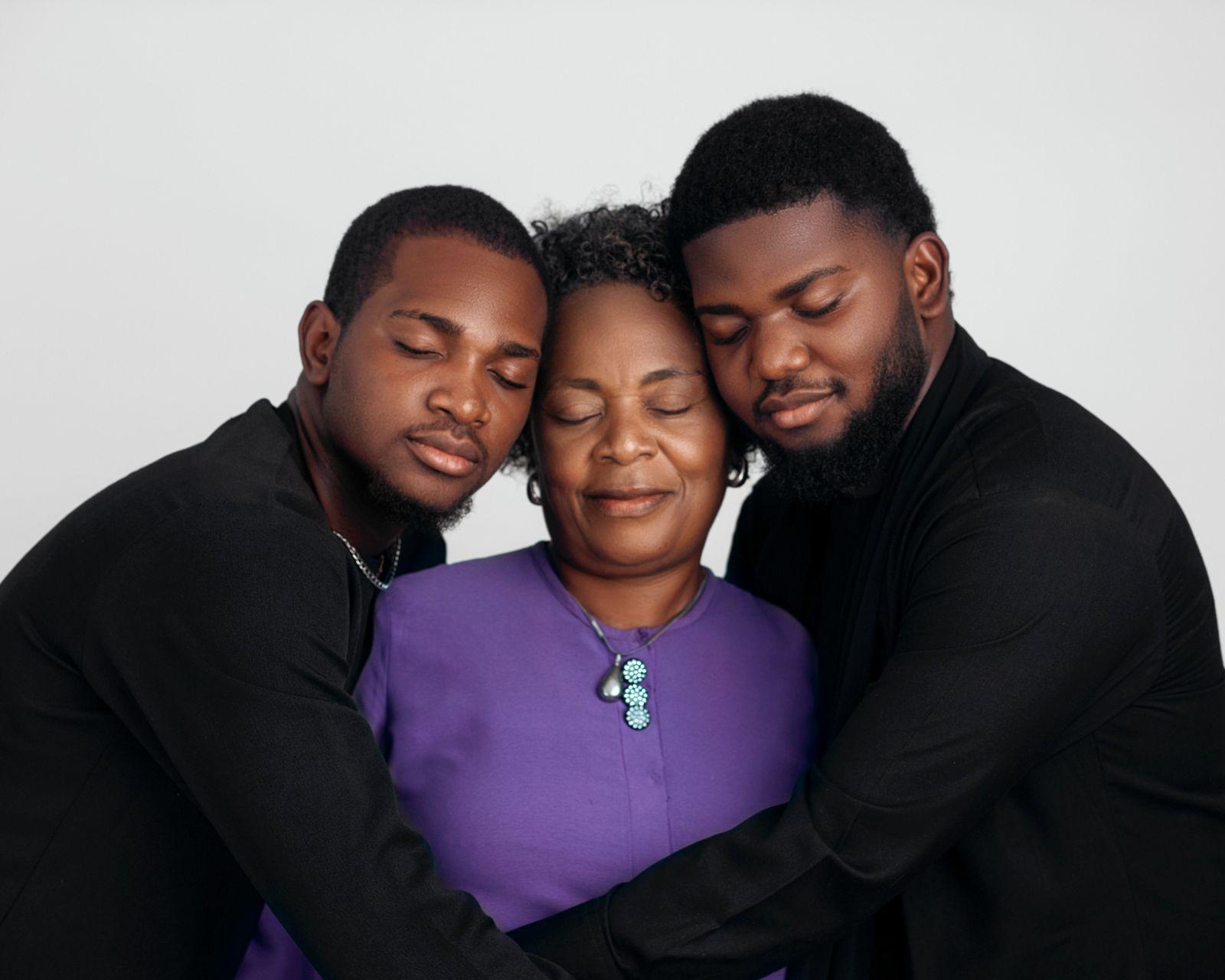 Dos hermanos adultos abrazando con cariño a su madre